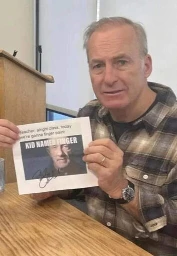 Bob Odenkirk holding an autographed printed meme. meme is kid named finger