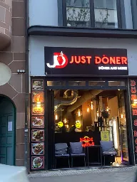 Photo of a döner-shop with the sign above the door saying "JUST DÖNER" and a smaller "döner and more" below.
